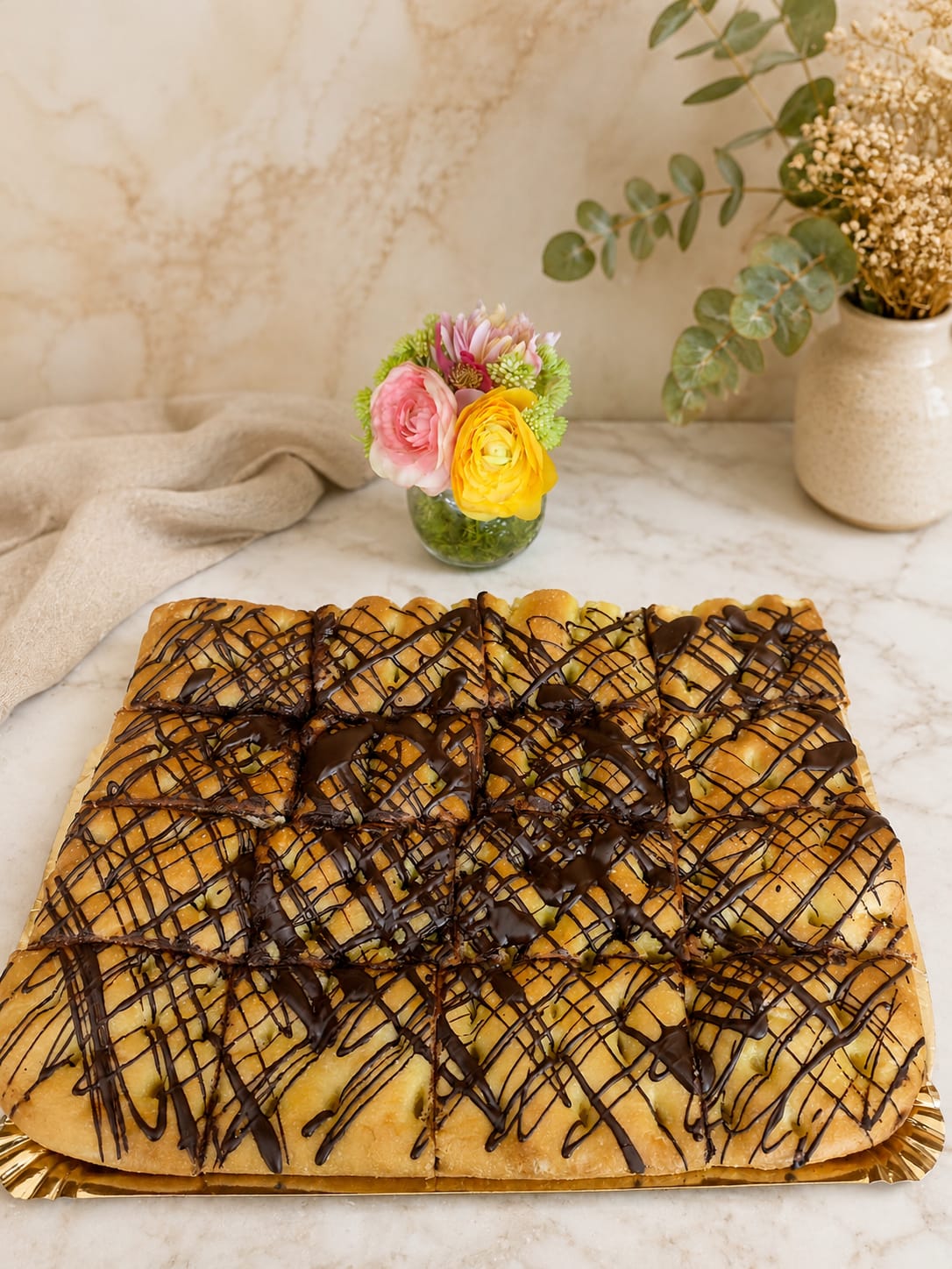 Coca dulce de toña en porciones con hilos de chocolate de Pasteleria Fernando en Novelda